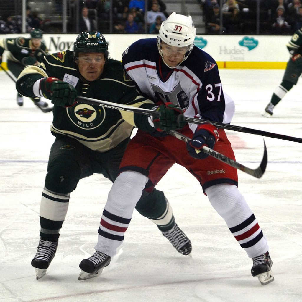 Monsters left winger Markus Hannikainen battles with a Iowa Wild player for possession. Photo by Ryan Kaczmarski