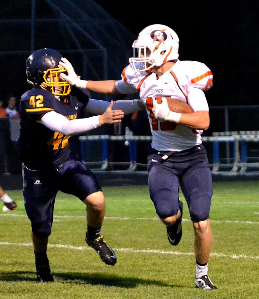 Berea-Midpark wide receiver Matt Hausler wards off Olmsted Falls sophomore linebacker Jaden Mendeluk for a big gain.